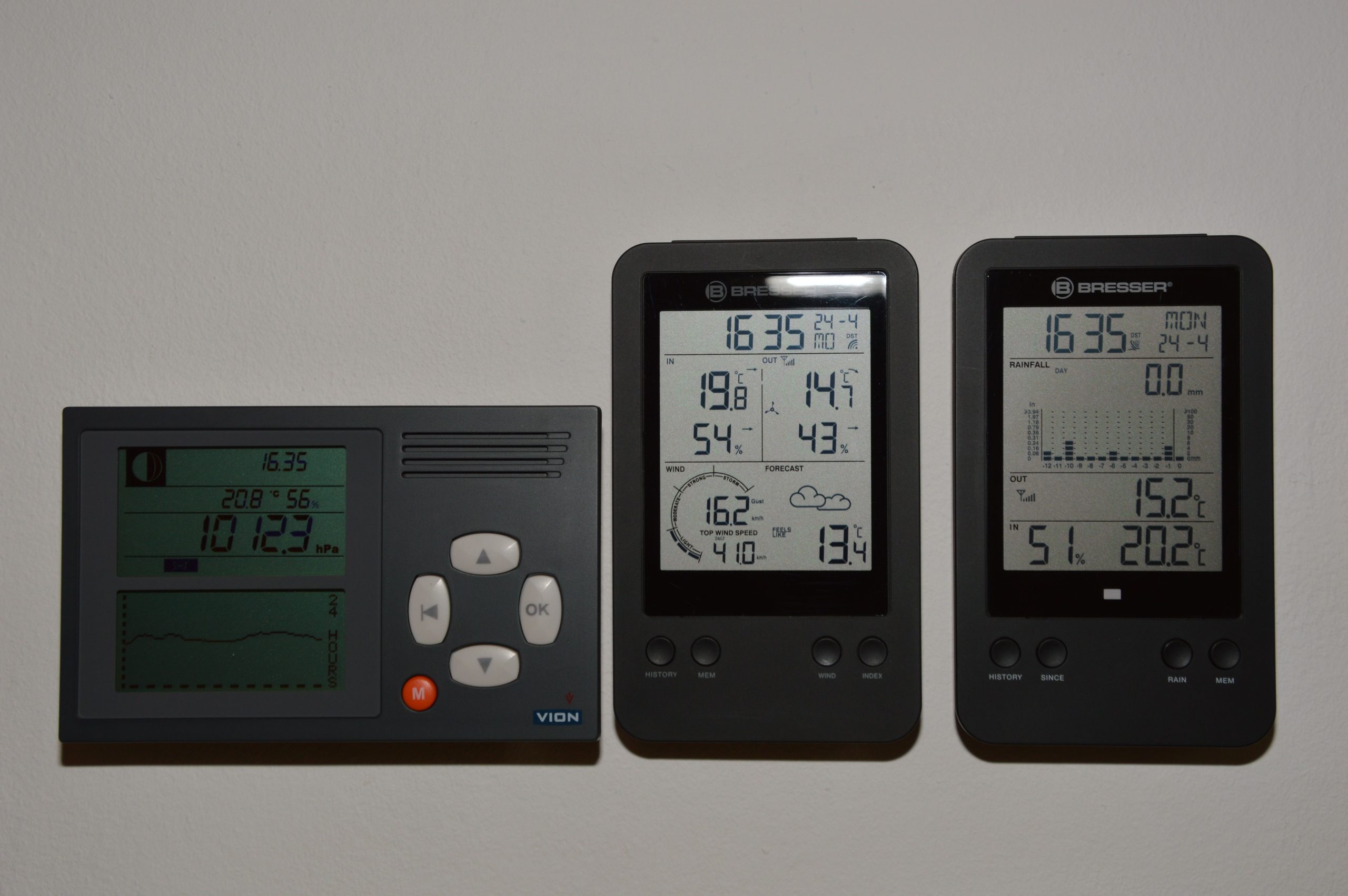 Applications Multiple digital weather monitors on a wall displaying temperature and pressure.