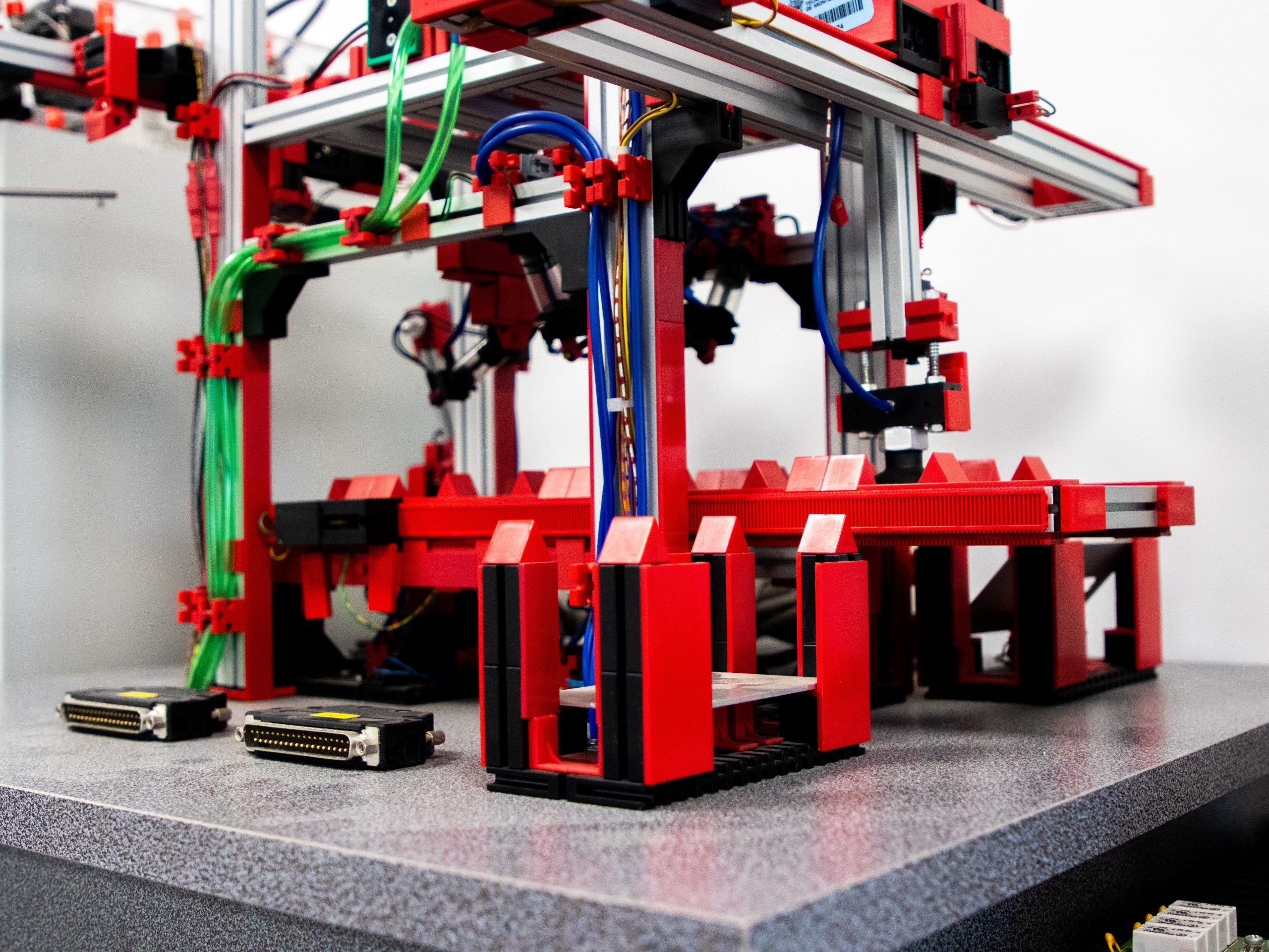 Applications Close-up view of a robotic assembly machine with vibrant red and metallic components.